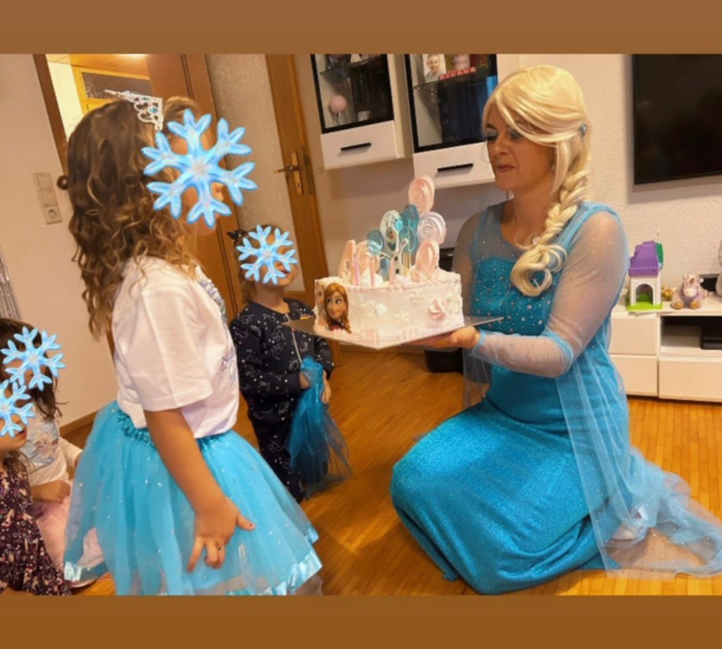 Elsa mit Kindern und bunten Tüchern im Garten